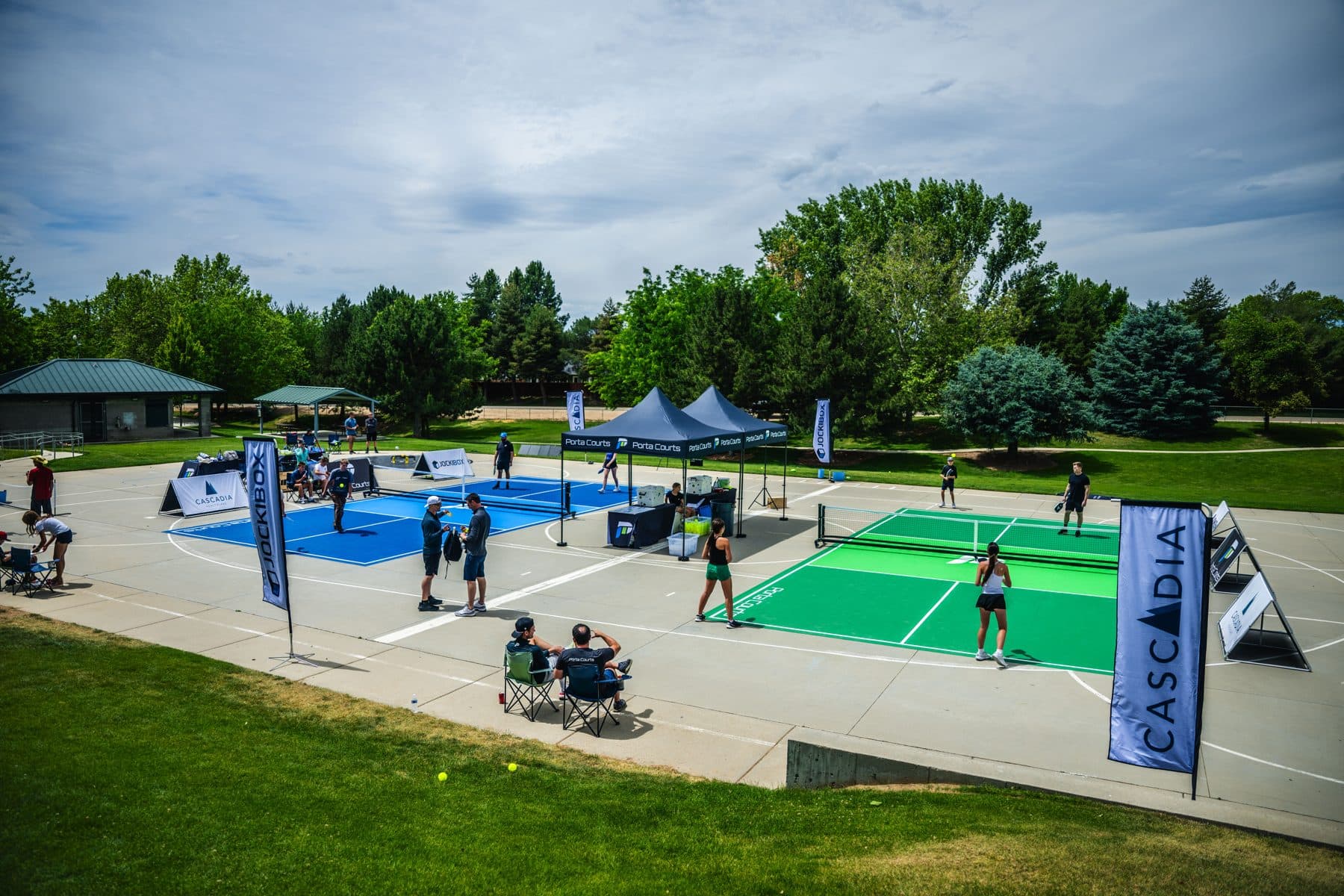 Two PortaCourts pickleball courts set up outdoors with players in action